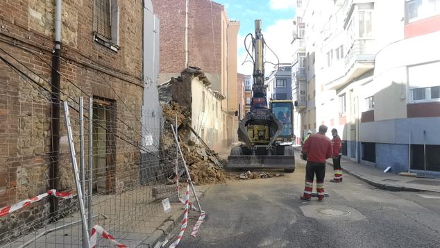 El derrumbe se ha producido cuando la máquina procedía al derribo de un inmueble en la calle Alfonso el Justiciero de León capital | Efectivos de Bomberos han acudido al lugar para auxiliar al operario que, finalmente, ha podido abandonar el vehículo sin dificultad. 