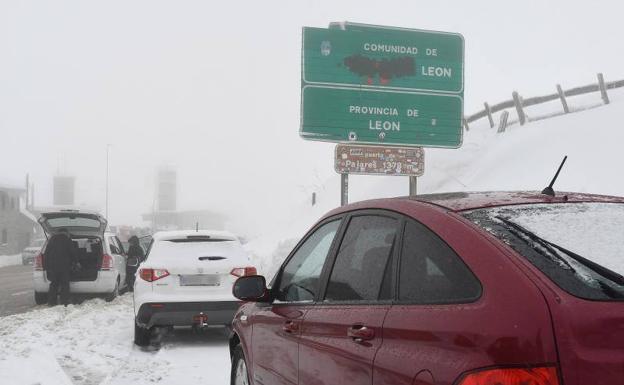 La nieve cubre las carreteras de salida y entrada de la provincia de León por el norte. En la imagen de archivo, coches parados por la nieve a la entrada del puerto de Pajares. En el vídeo, la nieve que caída de madrugada en Maraña.