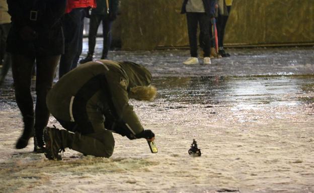 Imagen. Un joven realiza una fotografía con la nieve en la plaza de la Catedral. 