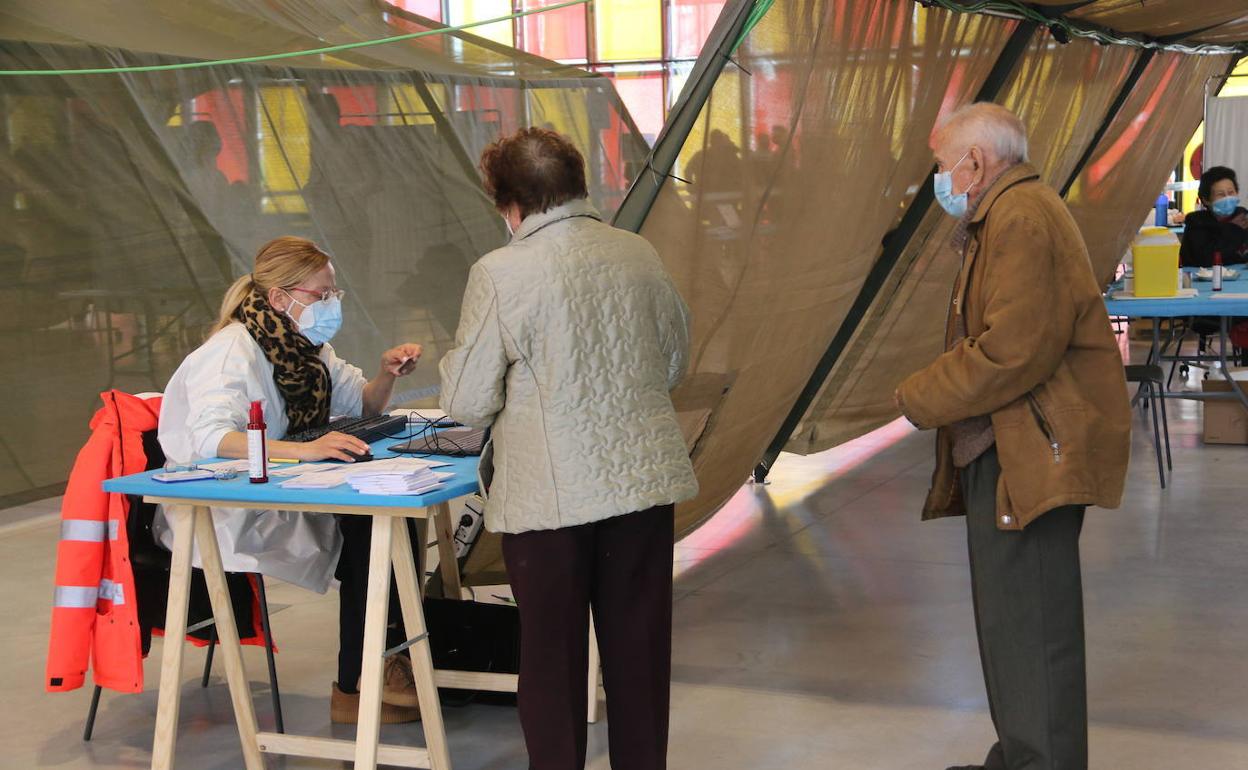 Una pareja registra su vacunación en el Palacio de Exposciones de León durante las vacunaciones masivas en la capital.