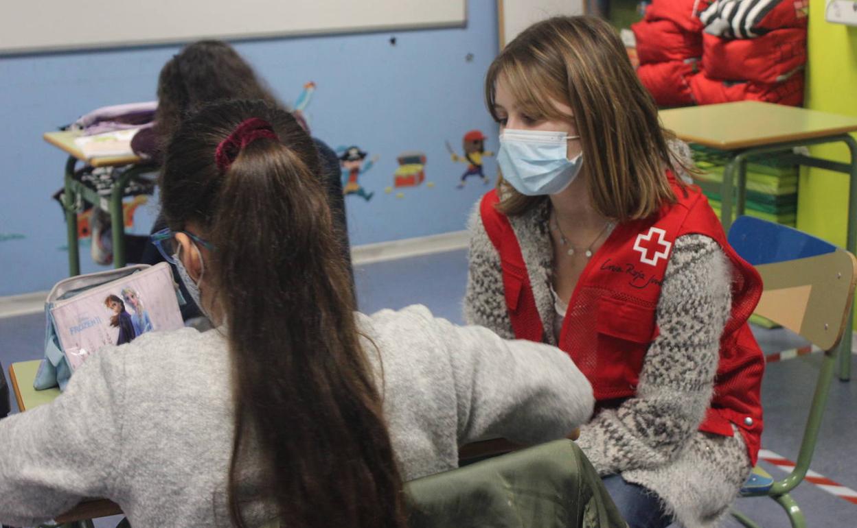E ldía 5 de dieimbre se celebra el día internacional del voluntariado. En la imagen, una voluntaria de Cruz Roja en una escuela.