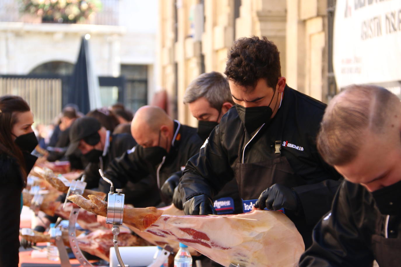 Centenares de personas participan en el corte de platos de jamón por una acción benéfica.