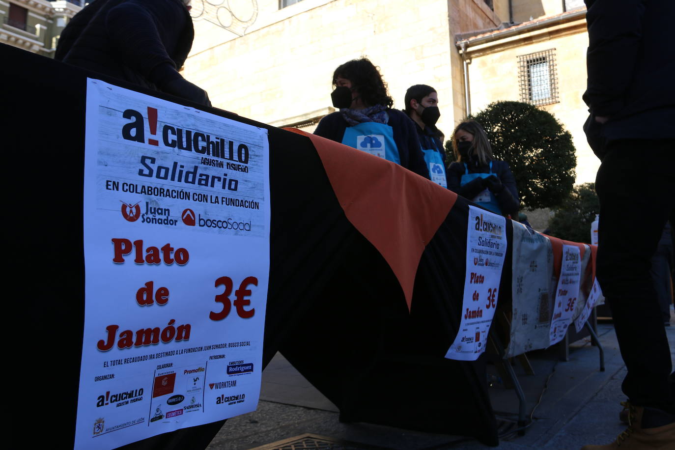 Centenares de personas participan en el corte de platos de jamón por una acción benéfica.