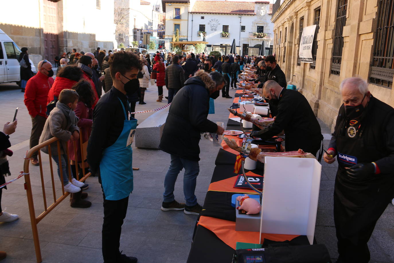 Centenares de personas participan en el corte de platos de jamón por una acción benéfica.