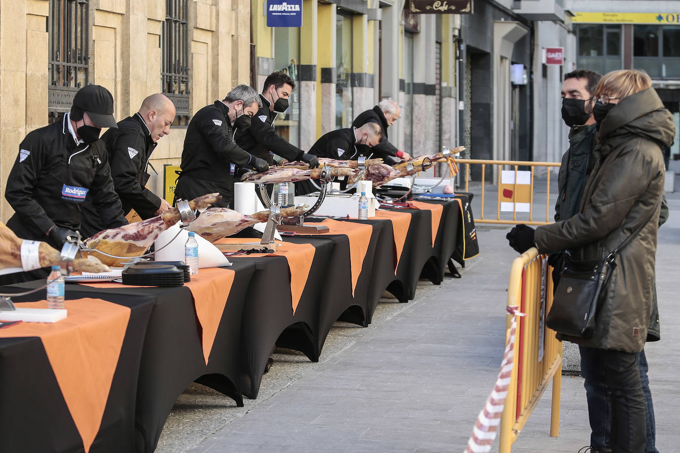 Centenares de personas participan en el corte de platos de jamón por una acción benéfica.