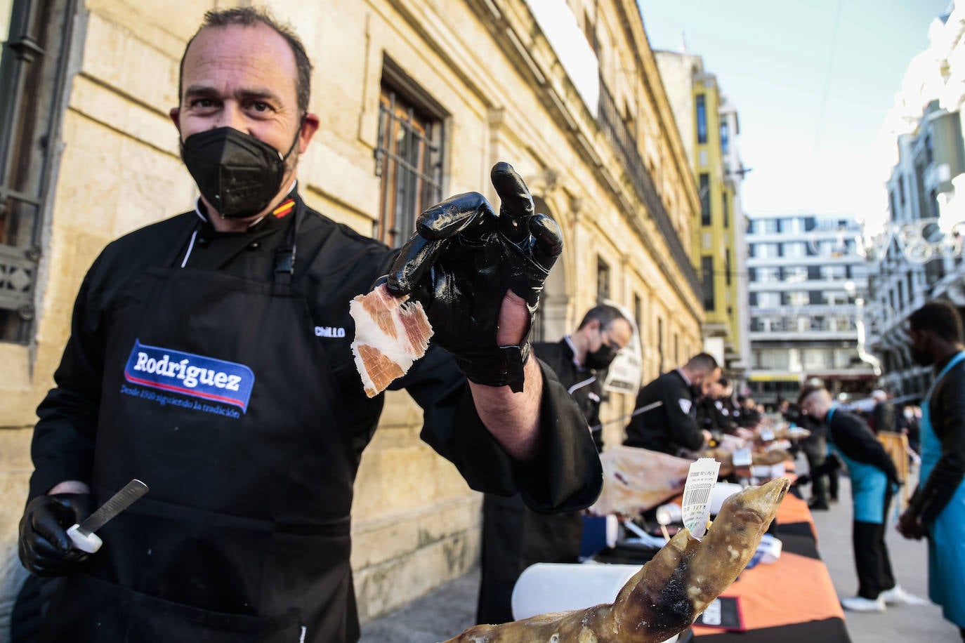 Centenares de personas participan en el corte de platos de jamón por una acción benéfica.