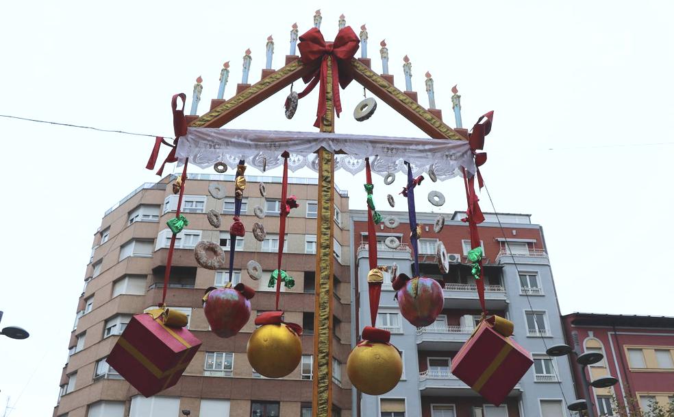 El ramo leonés, con sus tradicionales rosquillas, lazos, regalos y colores colgando, decora la plaza de las Cortes en León.