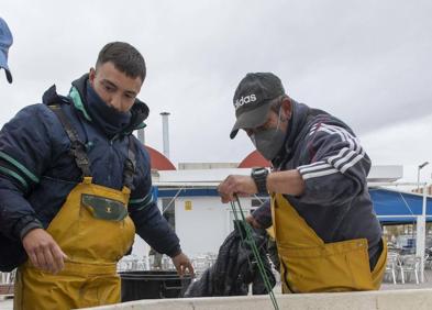 Imagen secundaria 1 - Mientras el hotel Cavanna resiste gracias a su cercanía al Mediterráneo, en zonas como Los Urrutias abundan las casas en venta o cerradas a cal y canto. Los carteles de 'se vende' deprecian los inmuebles, muchos ya antiguos, y atraen a los trabajadores inmigrantes del campo. En la otra imagen, pescadores del Mar Menor. 