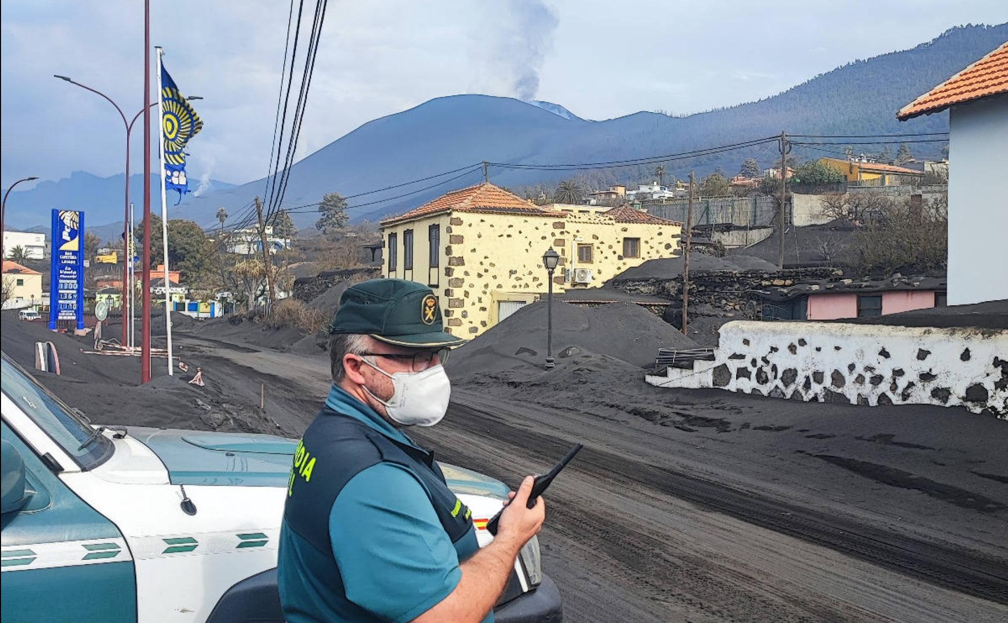 Guillermo controla el acceso a una de las zonas de exclusión en La Palma, con el volcán Cumbre Vieja al fondo. 