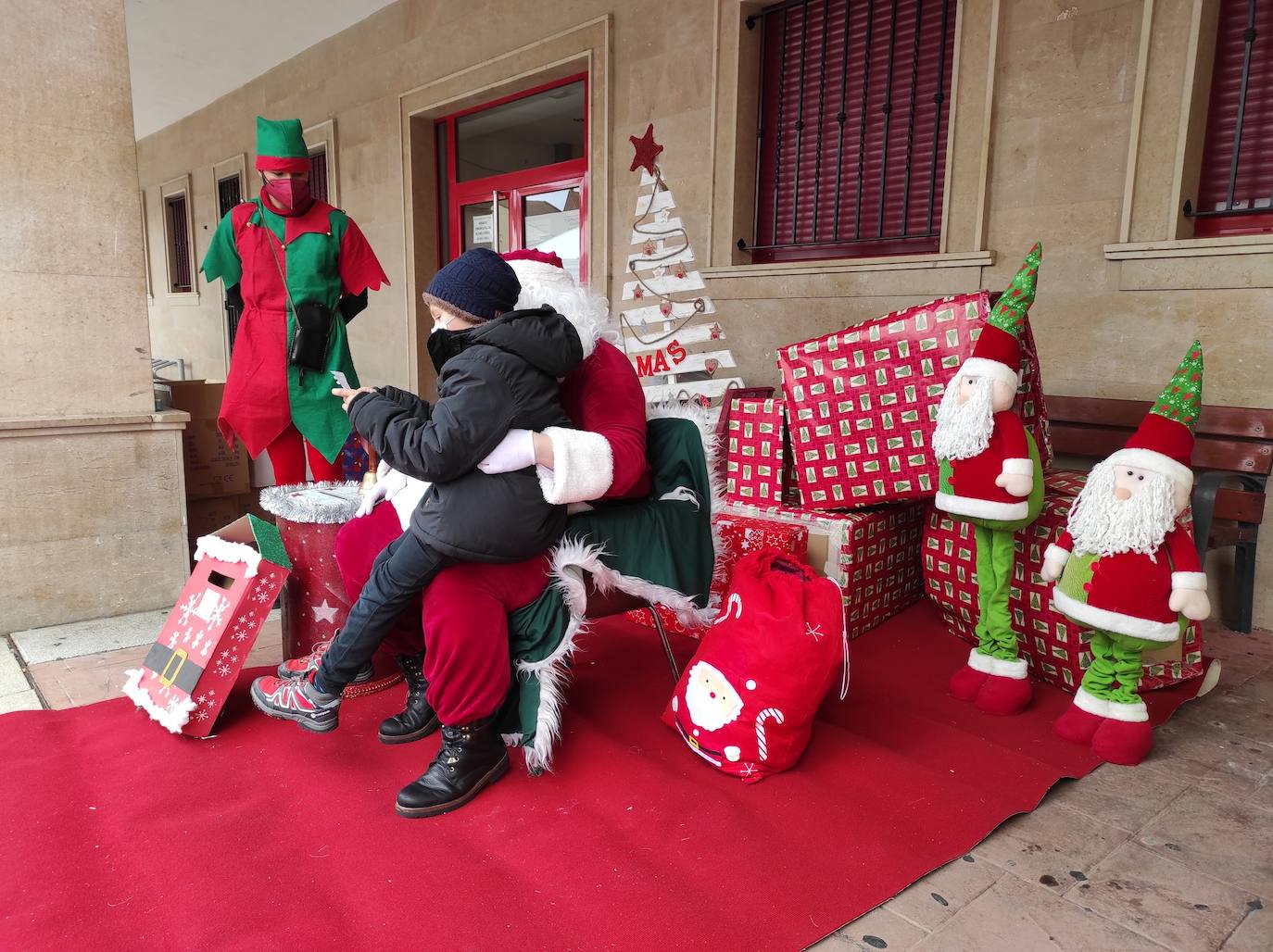 Papá Noel y su elfo recibieron a los niños de Valencia de Don Juan en uno de los soportales de la Plaza Mayor.