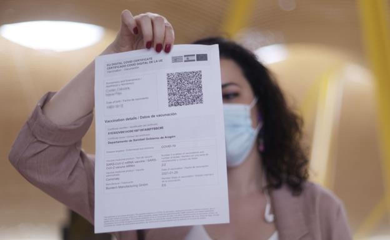 Imagen de archivo de una mujer mostrando su pasaporte covid con la pauta completa de la vacunación. 