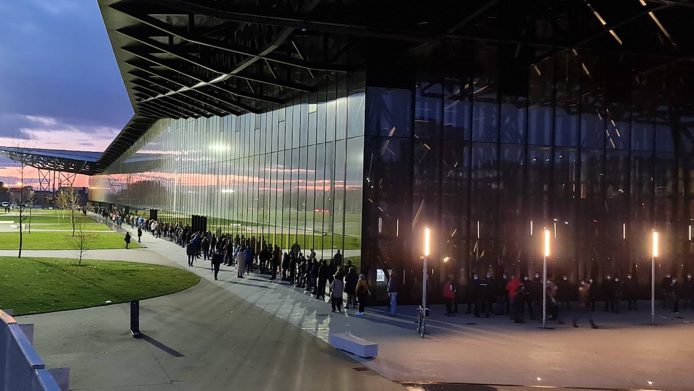 Una hora antes de la apertura de puertas en el 'vacunódromo' del Palacio de Exposiciones los leoneses 'de los 60' ya hacen cola para inocularse la tercera dosis | La cola, que ha llegado a alcanzar el kilómetro durante este martes, evidencia la alta respuesta al llamamiento. 