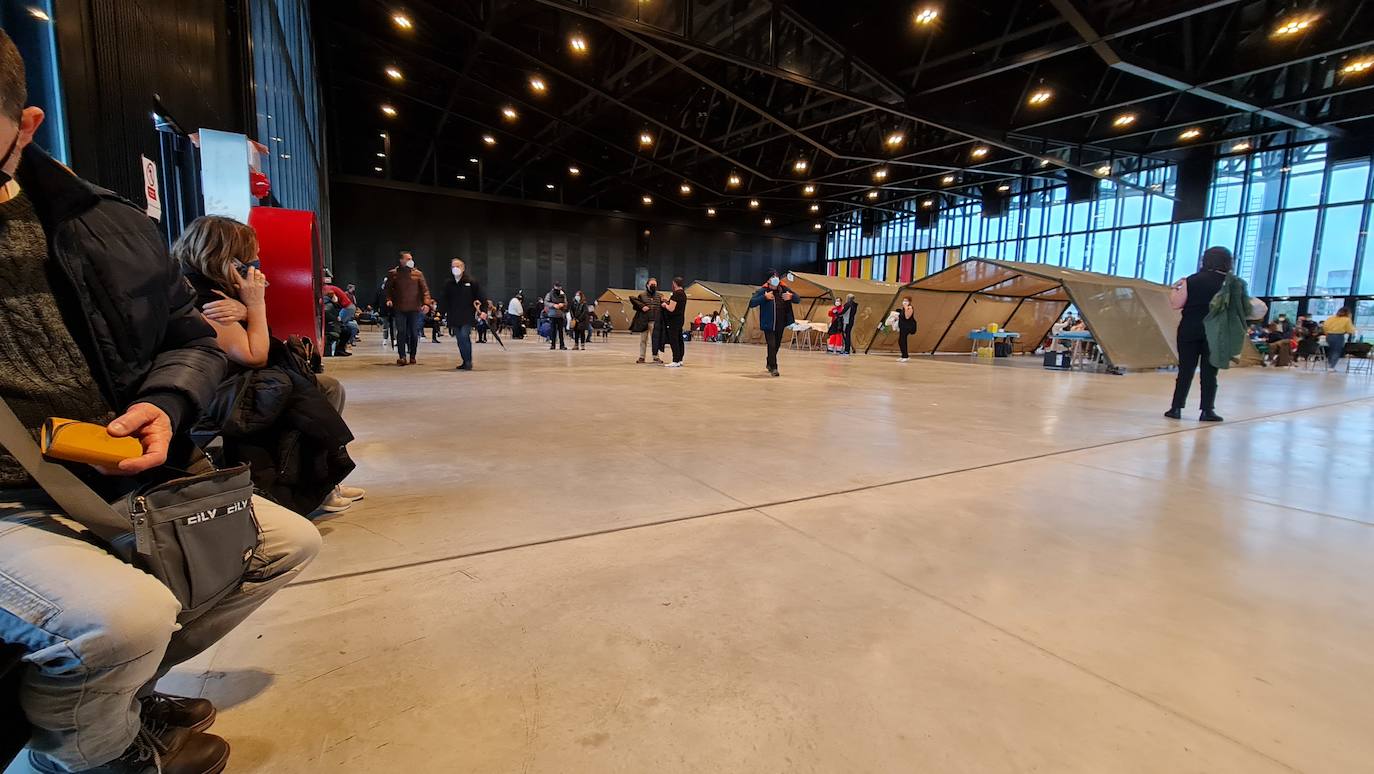 Una hora antes de la apertura de puertas en el 'vacunódromo' del Palacio de Exposiciones los leoneses 'de los 60' ya hacen cola para inocularse la tercera dosis | La cola, que ha llegado a alcanzar el kilómetro durante este martes, evidencia la alta respuesta al llamamiento. 