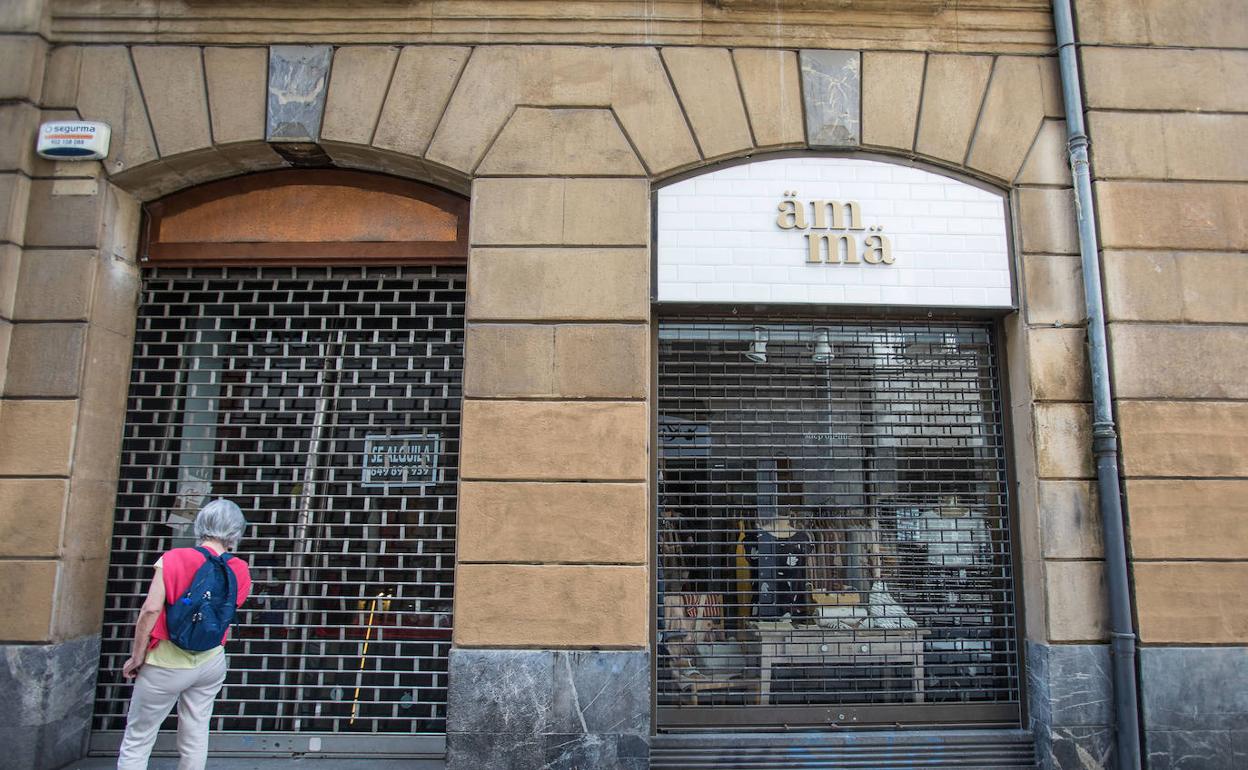 Tienda cerrada por liquidación junto a otro establecimiento en activo. 