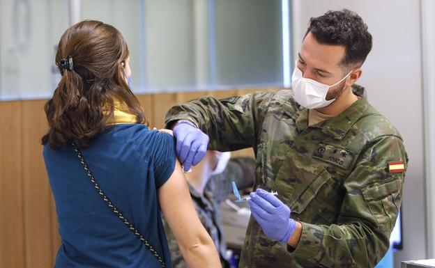 Un teniente del Cuerpo de Sanidad de las Fuerzas Armadas vacuna a una mujer en Baleares.