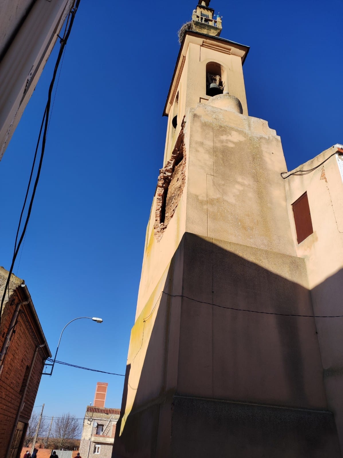 Tres viviendas aledañas han sido desalojadas tras la caída de una parte del recubrimiento de la torre de la iflesia en la localidad de Urdiales del Páramo. 