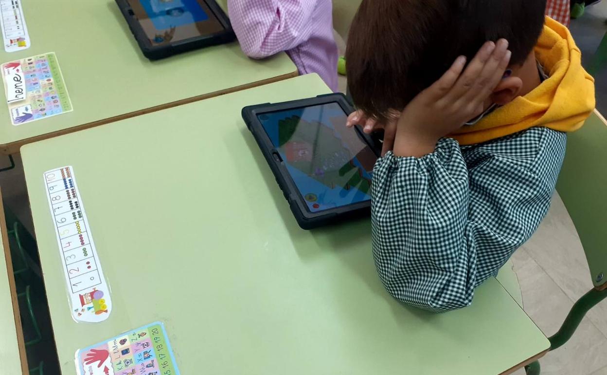 Escuela de Sariegos, donde un niño utiliza su tablet durante una clase.