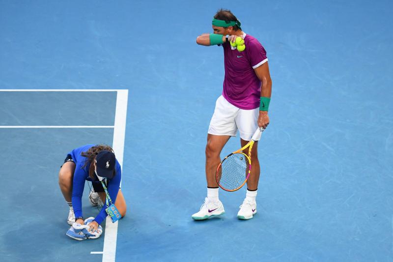 Una asistente seca el sudor de la pista durante la final. 