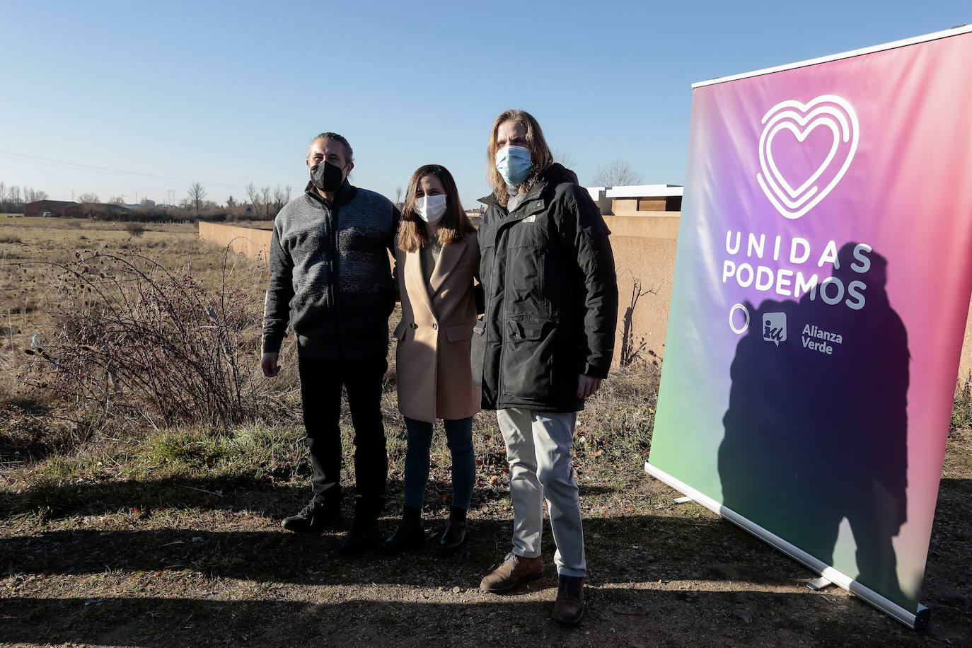 La secretaria general de Podemos y ministra de Derechos Sociales y Agenda 2030, Ione Belarra y el candidato a la Presidencia de Castilla y León, Pablo Fernández comparecen ante los terrenos en los que se construirá el nuevo instituto de Villaquilambre. Junto a ellos, el cabeza de lista por León, Sixto Martínez.