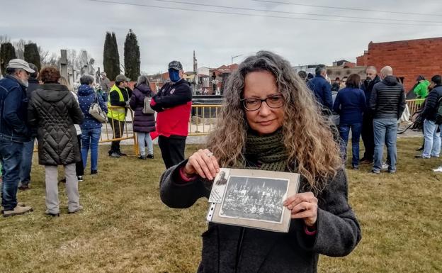 Galería. Una de las familiares muestra la foto de su abuelo en el cementerio de Villadangos