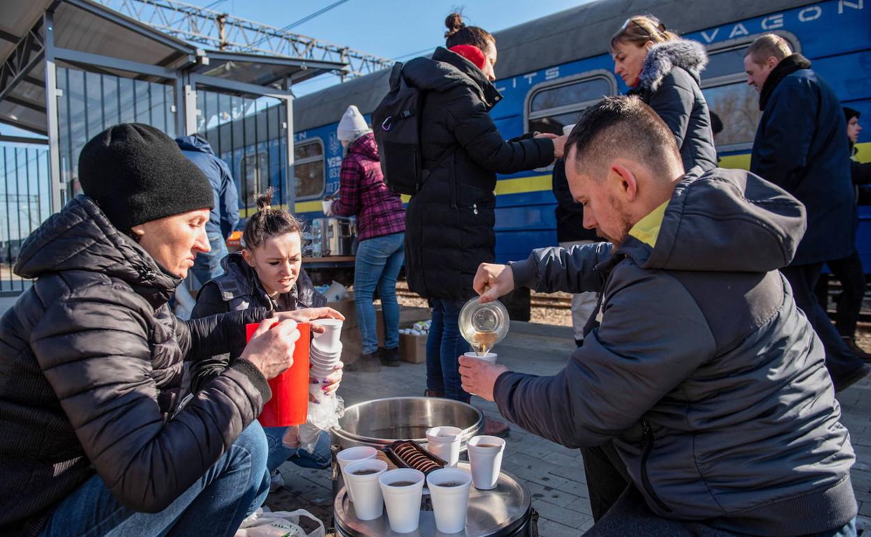 Un grupo de voluntarios reparten comida a los refugiados ucranianos que llegan a Polonia. 