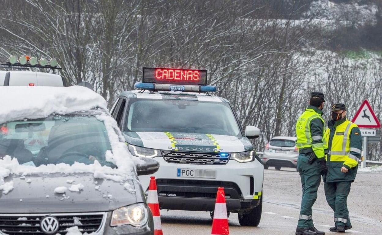 Efectivos de la Guardia Civil durante un control de carretera para comprobar el uso de cadenas. 
