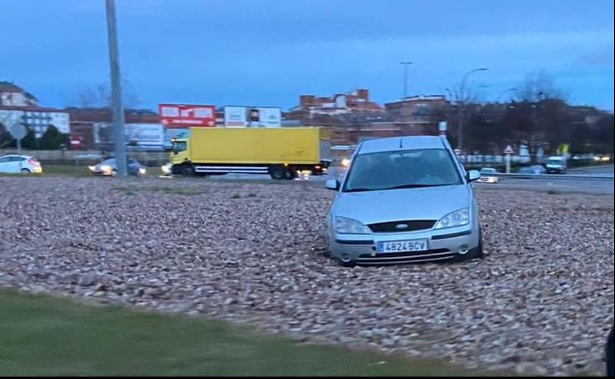 Imagen del vehículo en la rotonda tras salirse de la vía y quedar atrapado en la piedra. 