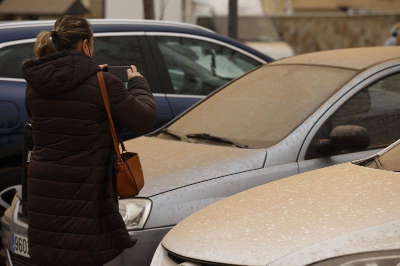 Una mujer hace una foto del polvo en suspensión que proviene del Sáhara que tras la lluvia acaecida en Madrid este martes ha teñido la ciudad de un color naranja.