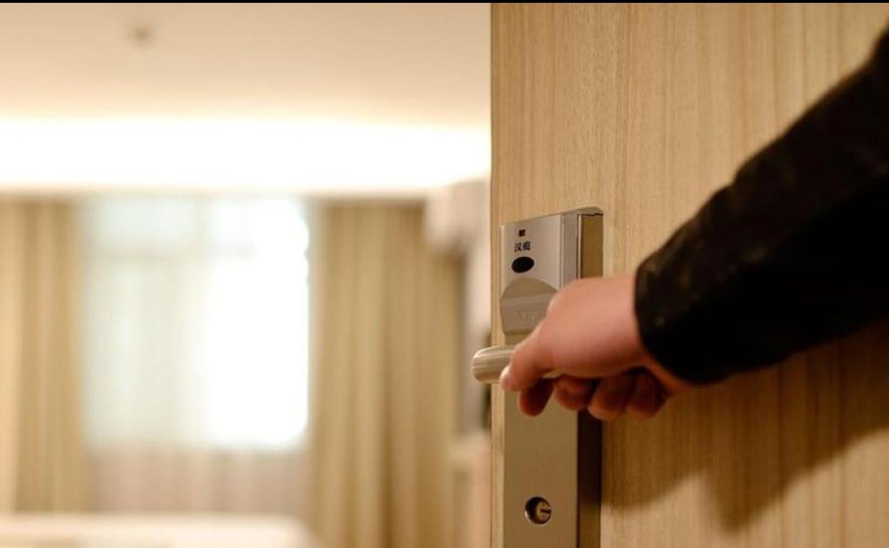 Imagen de archivo de un cliente accediendo a su habitación de hotel. 