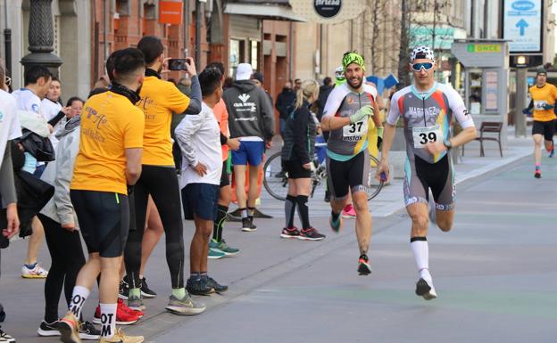 Los asistentes realizan fotos a los corredores en la III Carrera de las Empresas de leonoticias. 