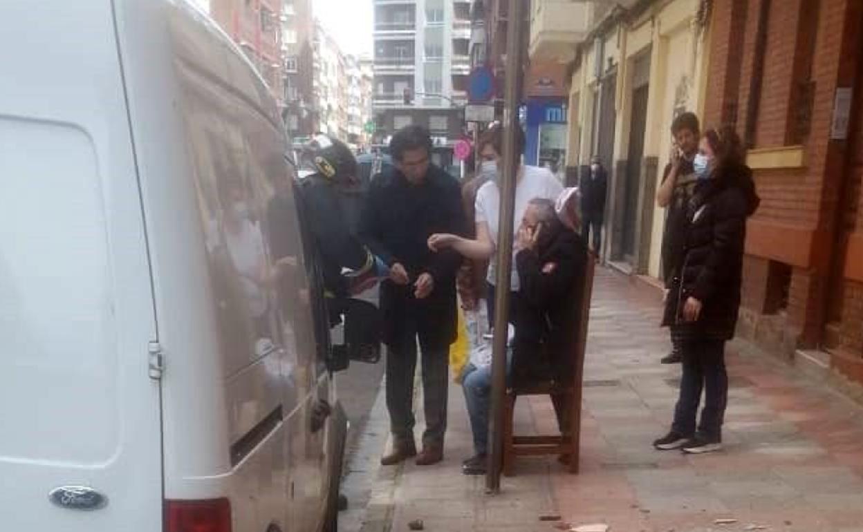 El herido recibe atención sanitaria tras desplomarse parte de una cornisa sobre su cuerpo.