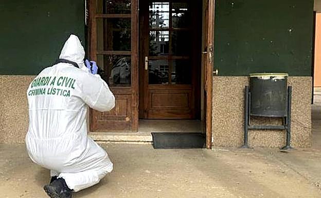 La Guardia Civil recoge pruebas en el portal del edificio donde fue asesinada la joven leonesa. 