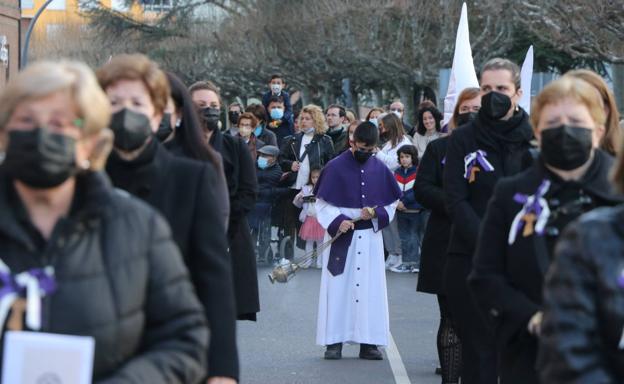 Las mujeres que van rezando los salmos del rosario de la buena muerte durante la procesión y un joven con un incensiario.