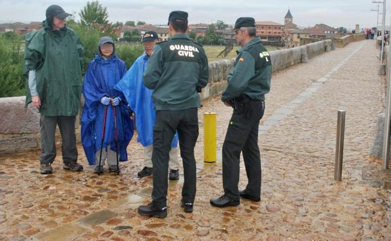 Efectivos de la Guardia Civil conversan con un grupo de peregrinos la localidad de Hospital de Órbigo. 