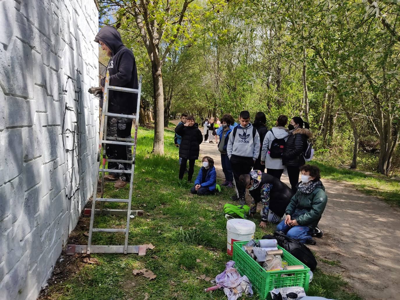 Los alumnos del colegio Jesús Maestro elaboran un mural en el Paseo del Río de Ponferrada.