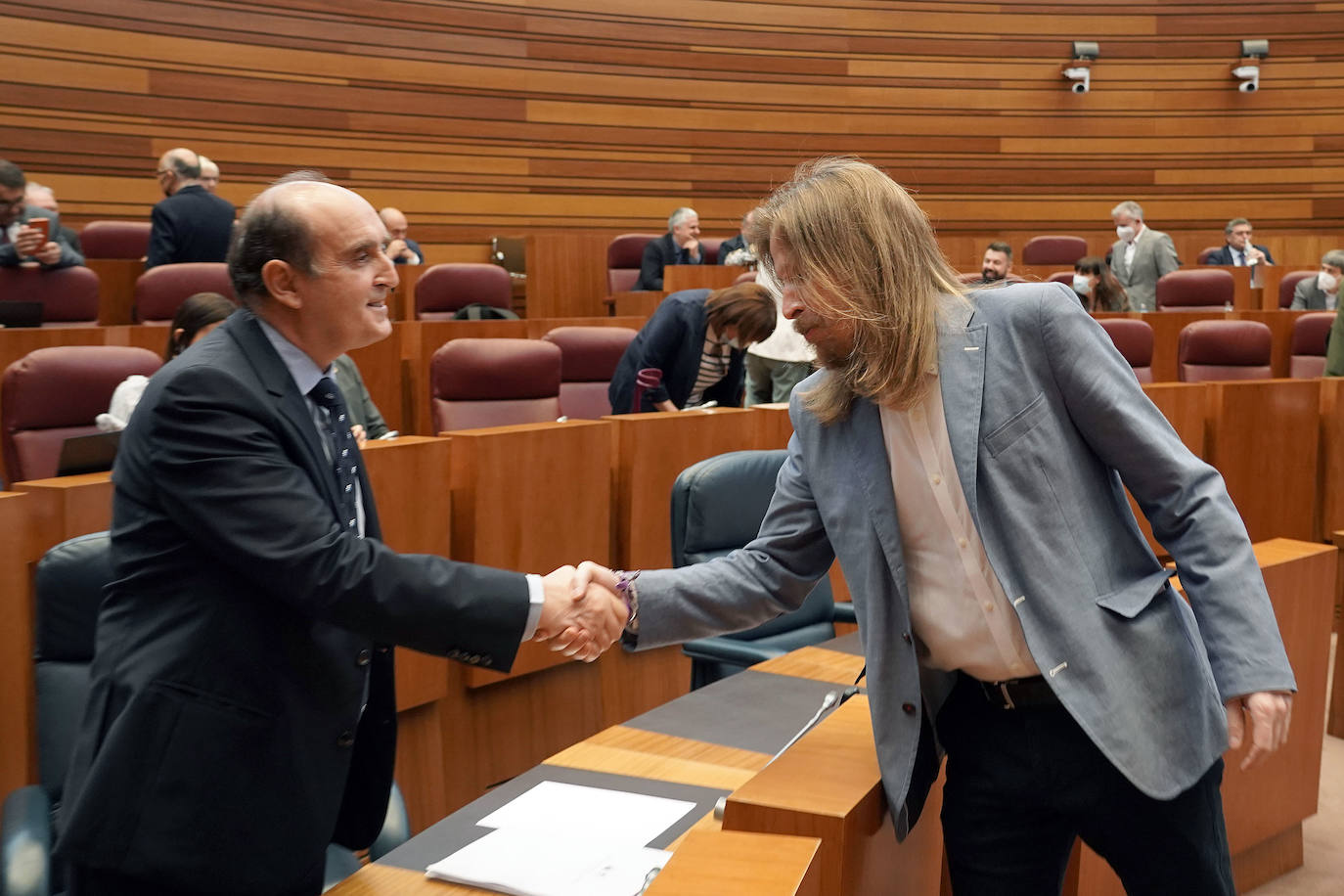El Procurador del Común, Tomás Quintana, saluda al procurador de Podemos, Pablo Fernández.