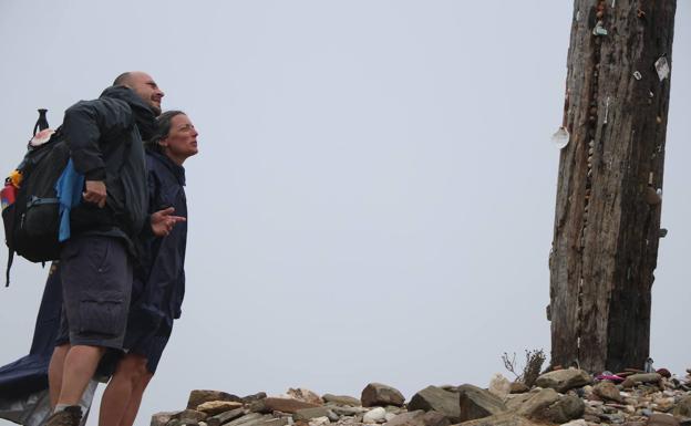 Galería. Dos peregrinos observan la Cruz de Fierro.