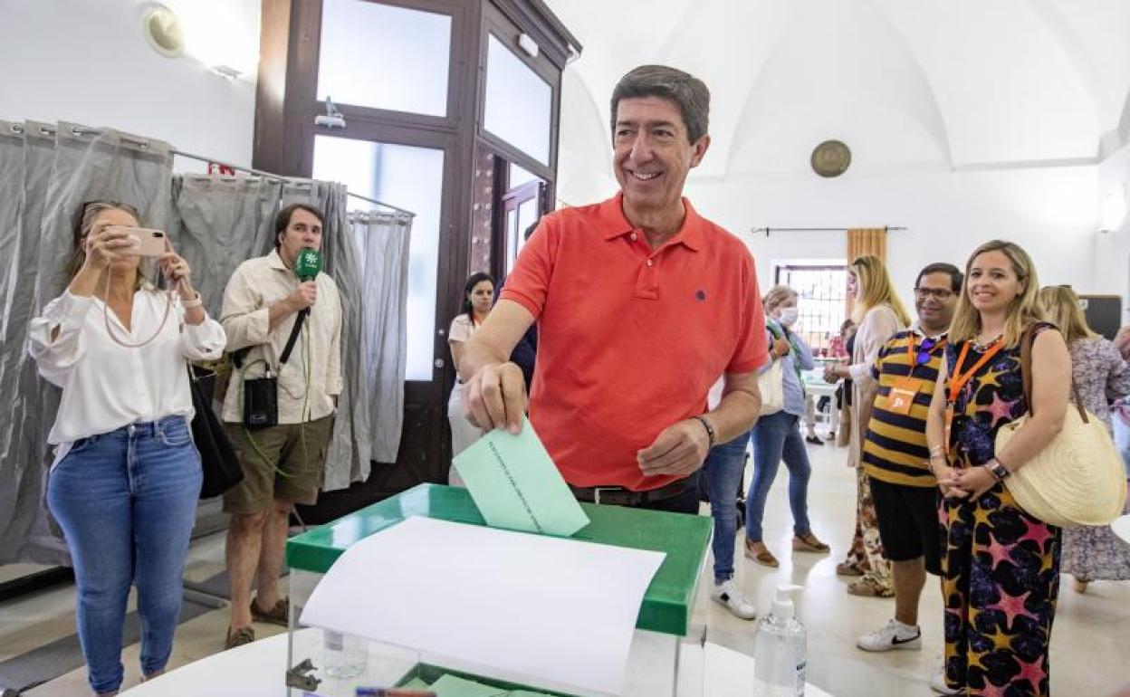 Juanma Moreno comparece ante los medios tras ejercer su derecho a voto, este domingo, en Málaga.