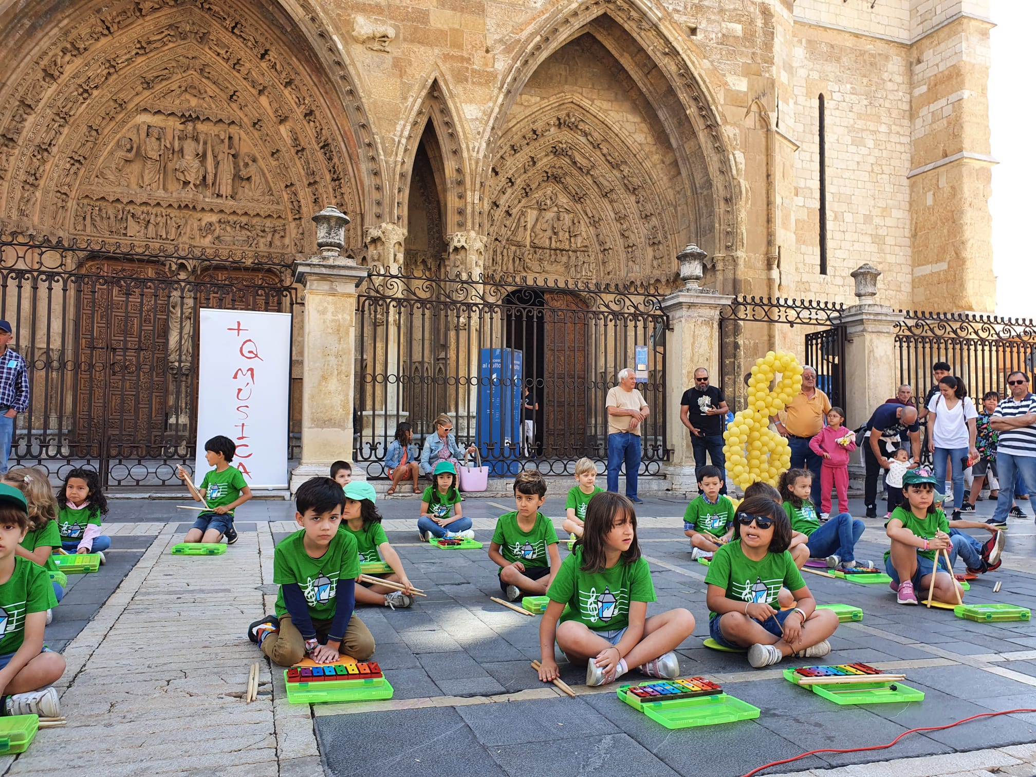 Música solidaria a los pies de la Catedral. Los pequeños alumnos de '+QMÚSICA' han sacado sus instrumentos en la plza de la Regla para mostrar las acciones sociales que realiza la Sociedad de San Vicente de Paúl.
