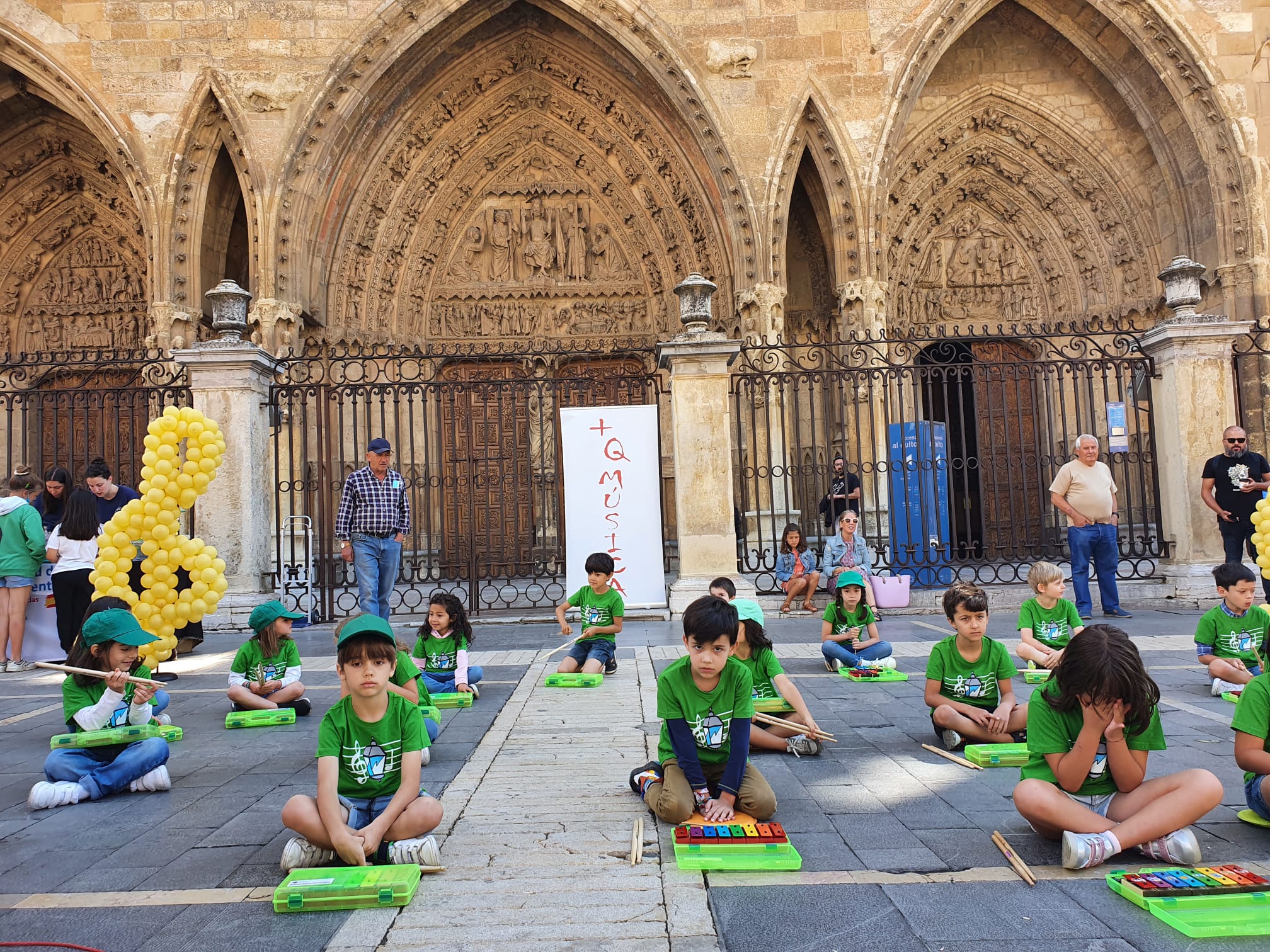 Música solidaria a los pies de la Catedral. Los pequeños alumnos de '+QMÚSICA' han sacado sus instrumentos en la plza de la Regla para mostrar las acciones sociales que realiza la Sociedad de San Vicente de Paúl.