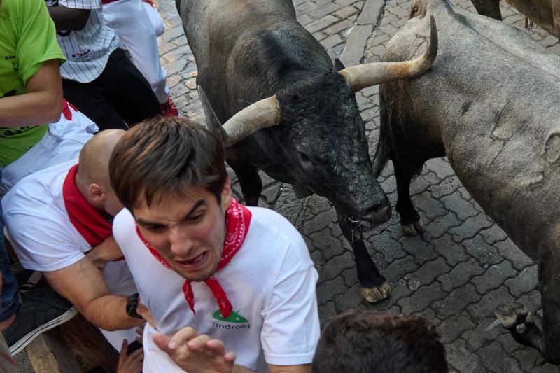 Los mozos corren ante los toros de la ganadería de José Escolar durante el tercer del encierro de San Fermín.