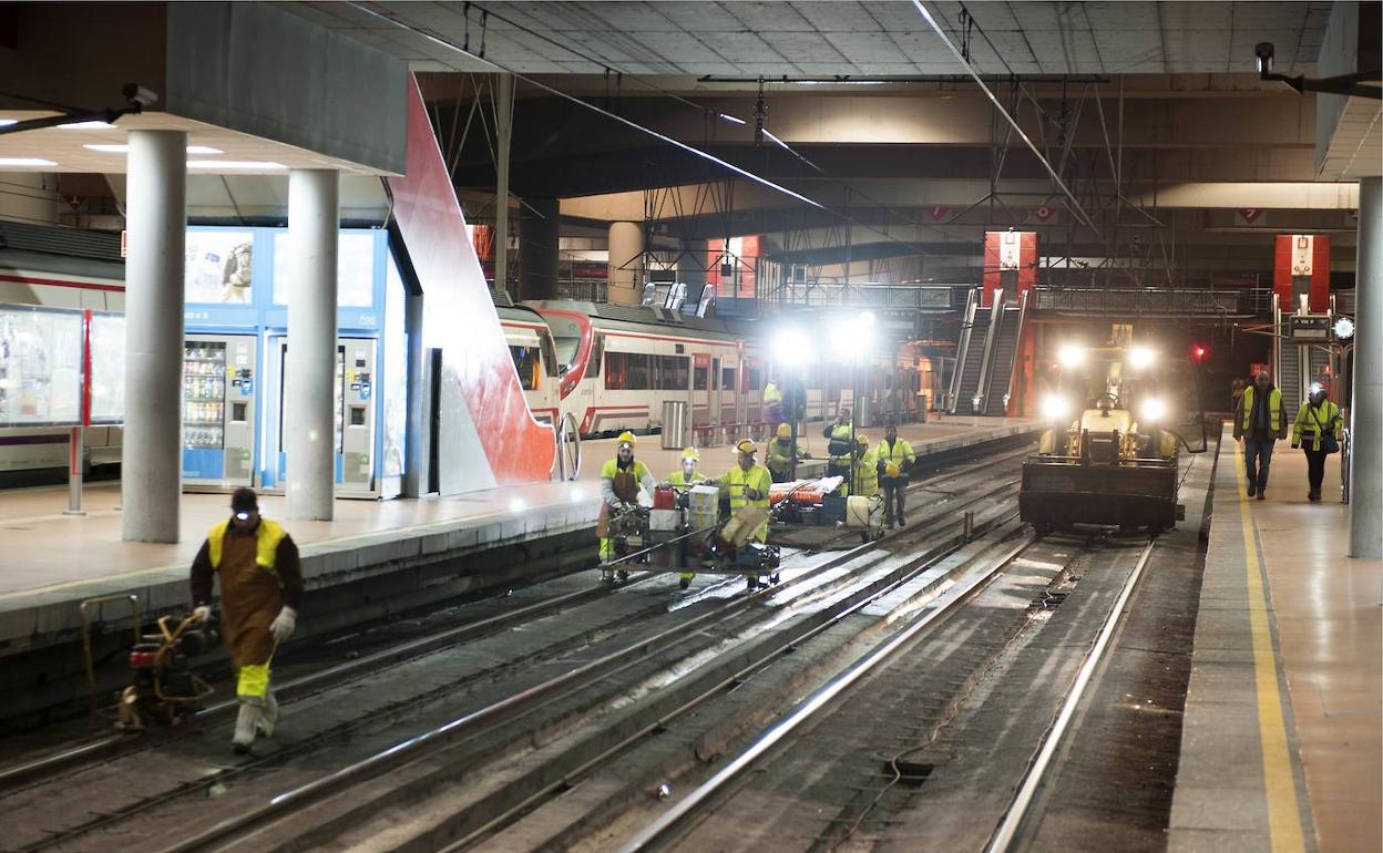 Imagen de trabajadores de Adif en las vías de una estación de tren. 