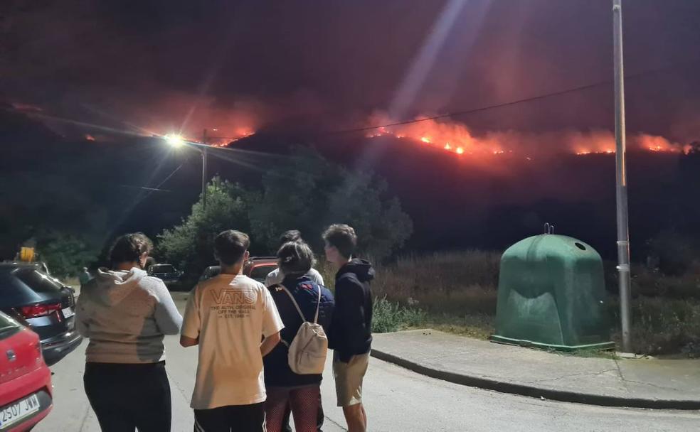 Los vecinos de San Pedro 'vigilan' la evolución del fuego desde el pabellón de Puente, donde pasarán la noche. 