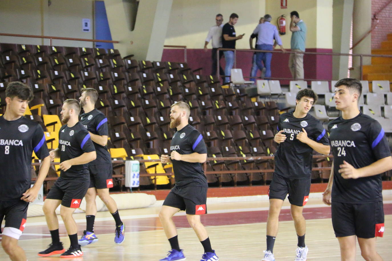 La plantilla del Ademar realiza flexiones en medio de la cancha del Palacio de los Deportes. 