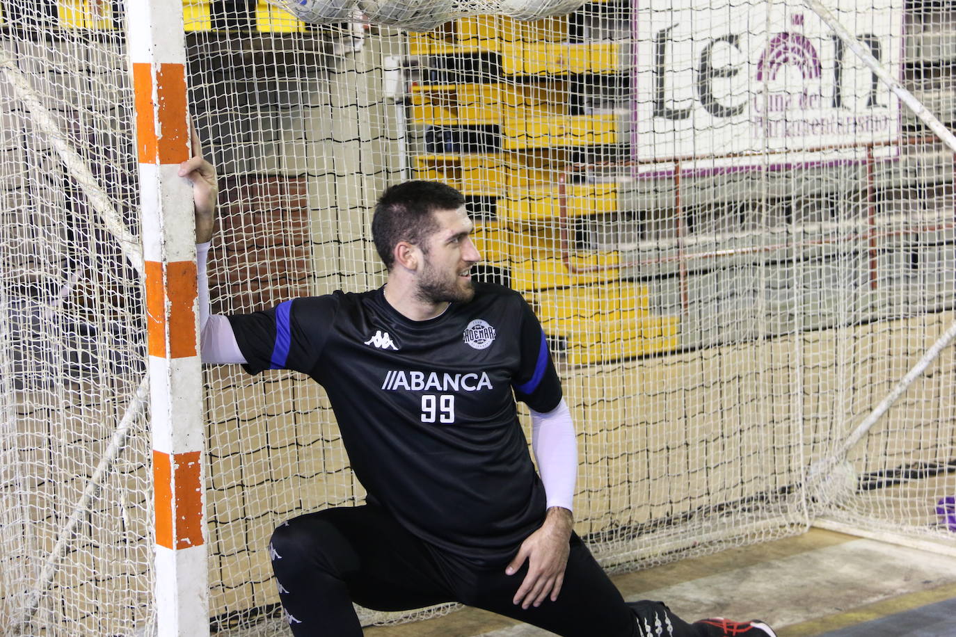 La plantilla del Ademar realiza flexiones en medio de la cancha del Palacio de los Deportes. 