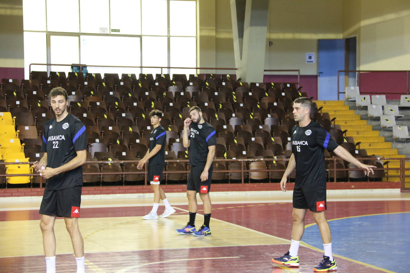 La plantilla del Ademar realiza flexiones en medio de la cancha del Palacio de los Deportes. 