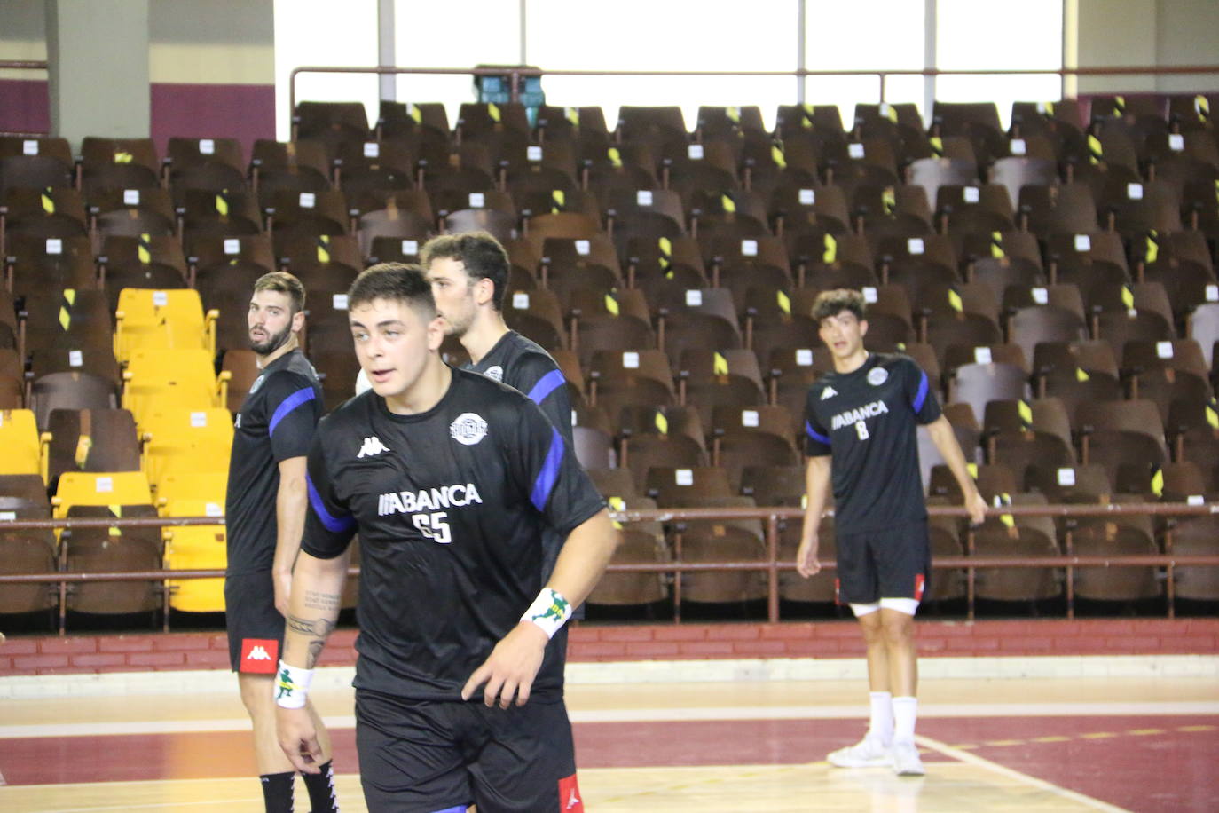 La plantilla del Ademar realiza flexiones en medio de la cancha del Palacio de los Deportes. 