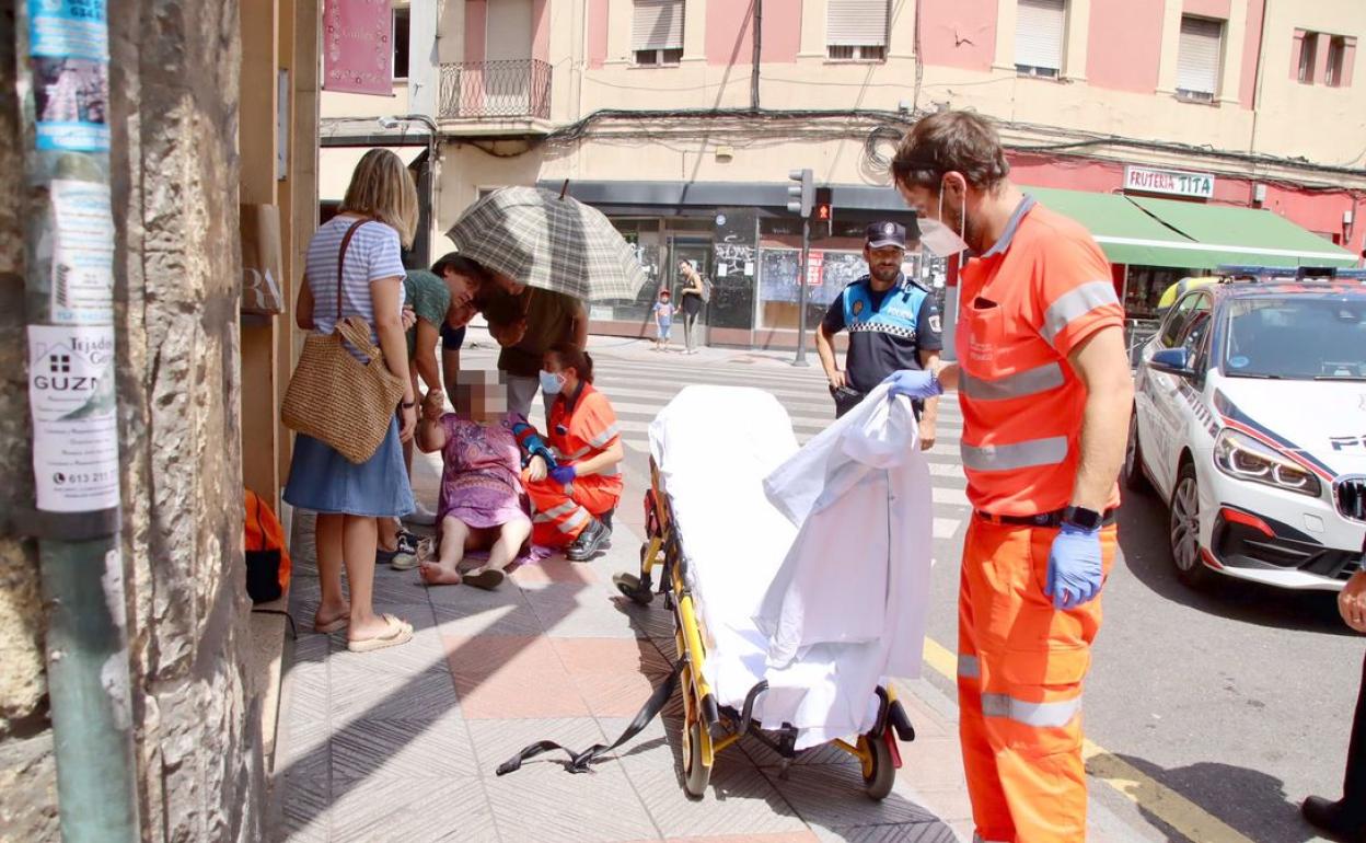 Sanitarios atienden a una mujer por un golpe de calor en una calle de León. 