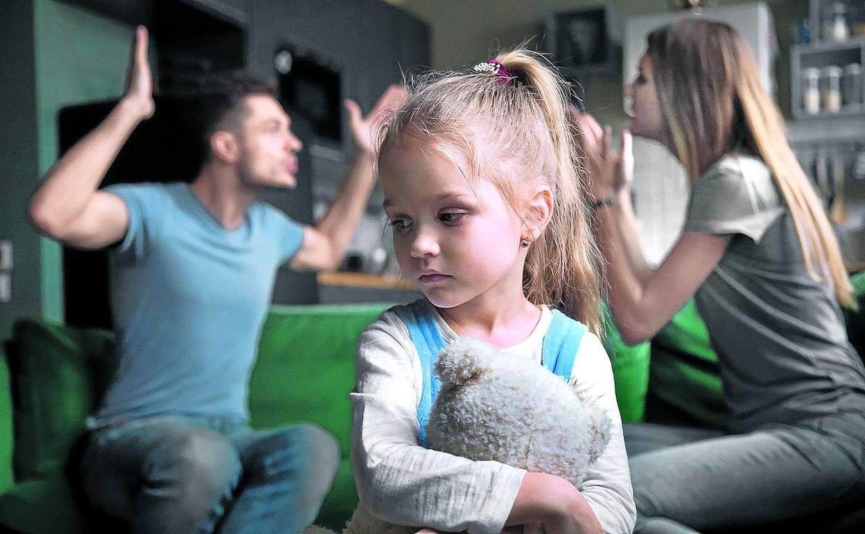 Imagen de archivo de una pareja discutiendo con una hija en medio. 