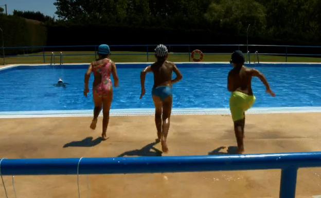 Varios niños se disponen a saltar a la piscina municipal de Valdevimbre.